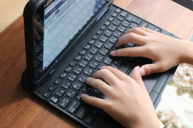 子どもが小さめのノートパソコンに触れている様子